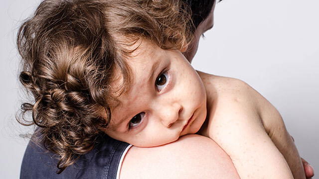 child laying on mom's shoulder