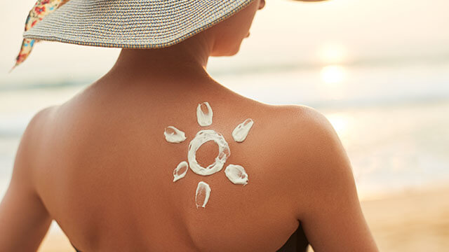 woman applying sunscreen creme